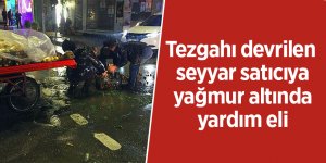 Tezgahı devrilen seyyar satıcıya, yağmur altında yardım eli